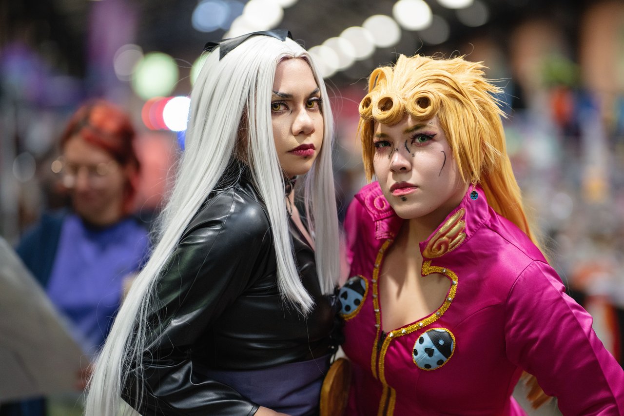 Anime cosplay enthusiasts in vibrant costumes at a convention in San José, Costa Rica.