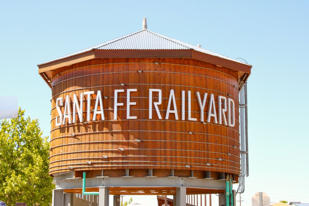 Iconic wooden water tower at Santa Fe Railyard, New Mexico, on a sunny day.