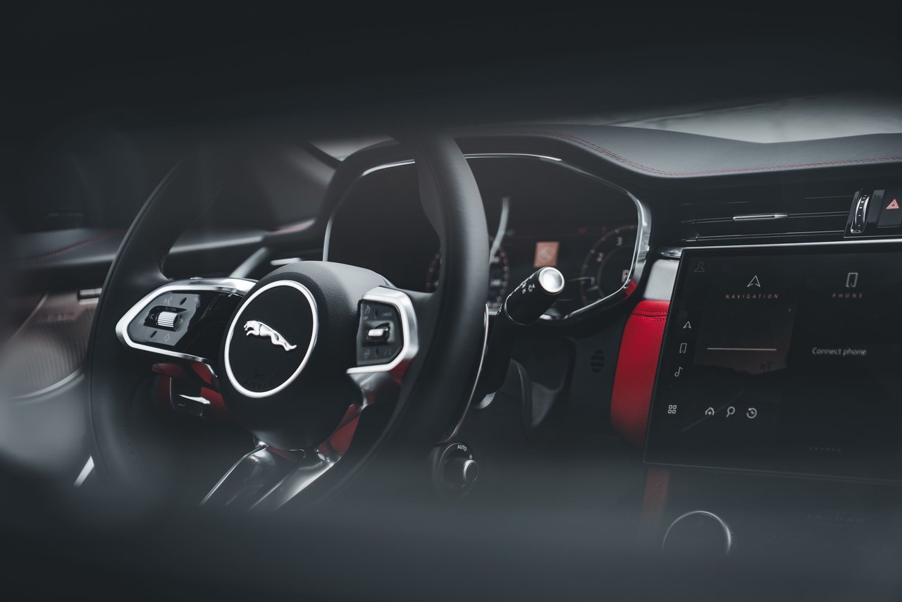 Sleek Jaguar SUV interior showcasing the modern steering wheel and dashboard features.
