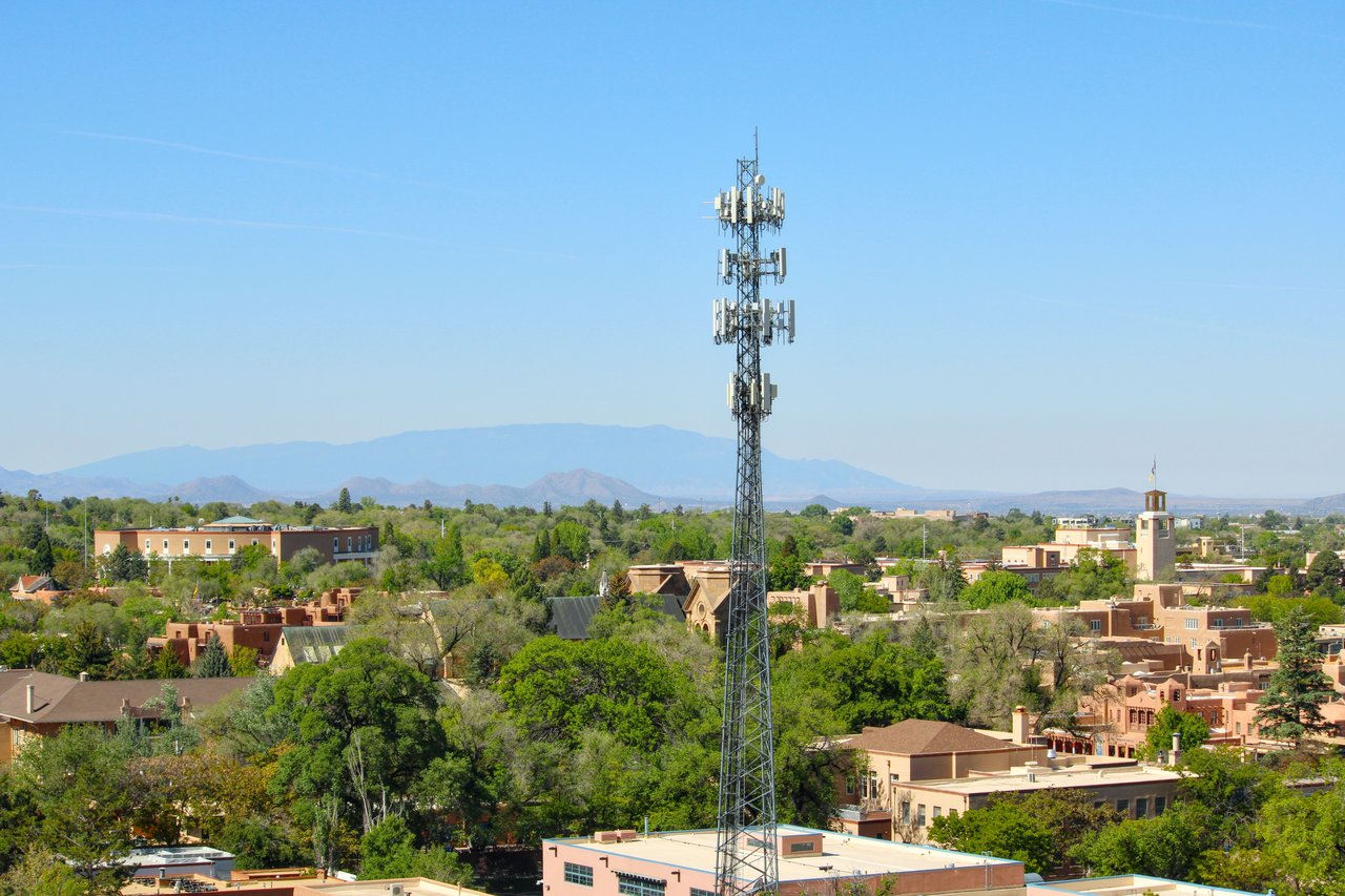 A scenic aerial view of Santa Fe, NM, featuring a cell tower and classic adobe architecture.