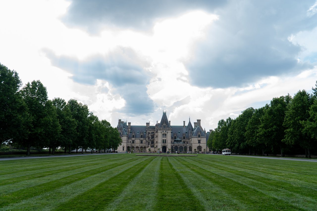 Scenic view of Biltmore Estate in Asheville, NC, with dramatic sky.