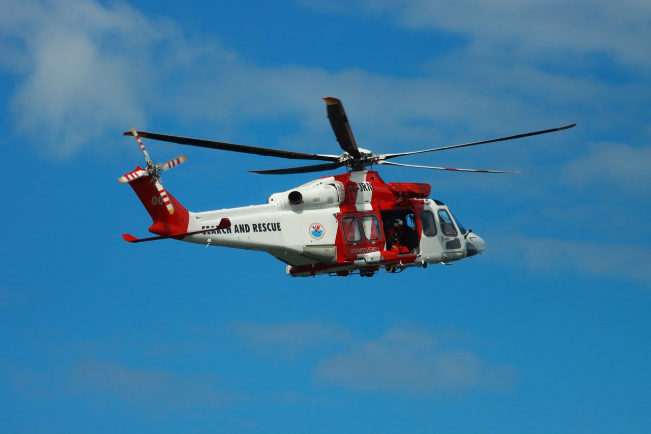 Helicopter flying in blue sky during a search and rescue operation in Sweden.
