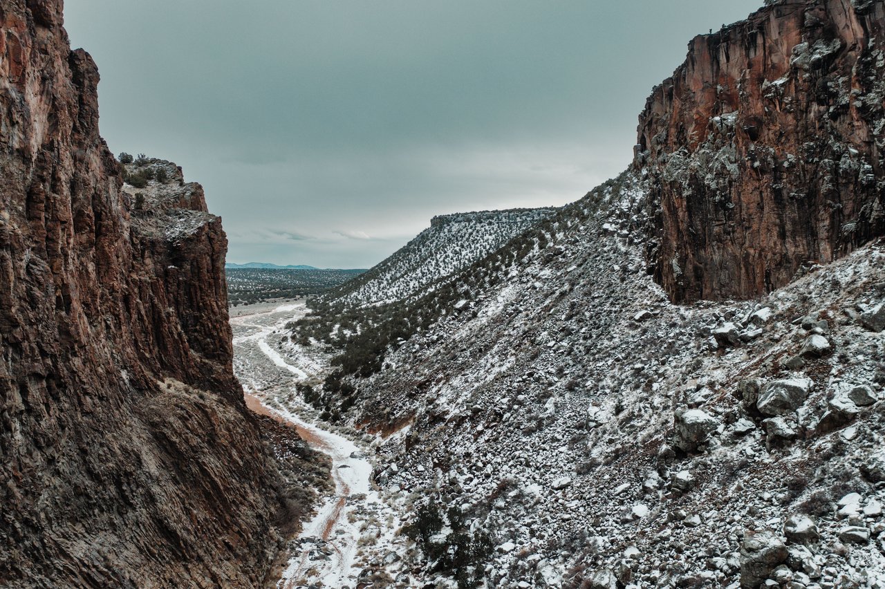 Drone captures rocky, snow-dusted canyon landscape in White Rock, New Mexico.