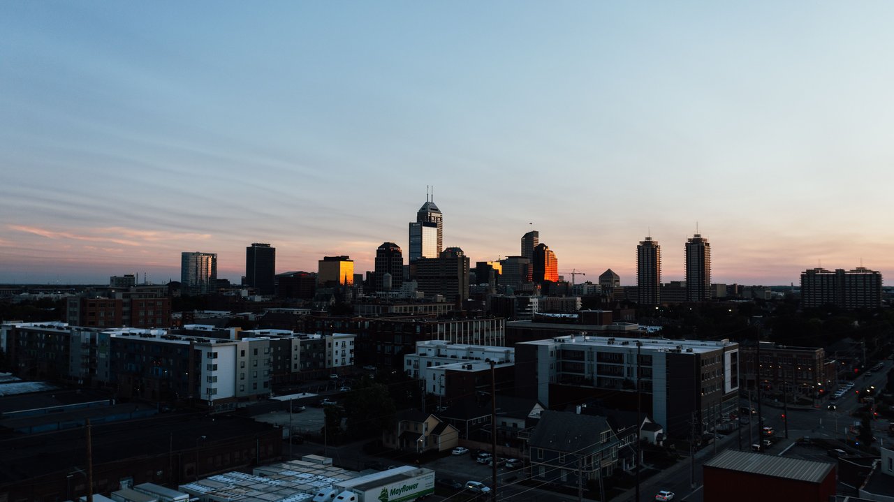 Aerial view of the Indianapolis skyline during sunset with a clear sky backdrop.