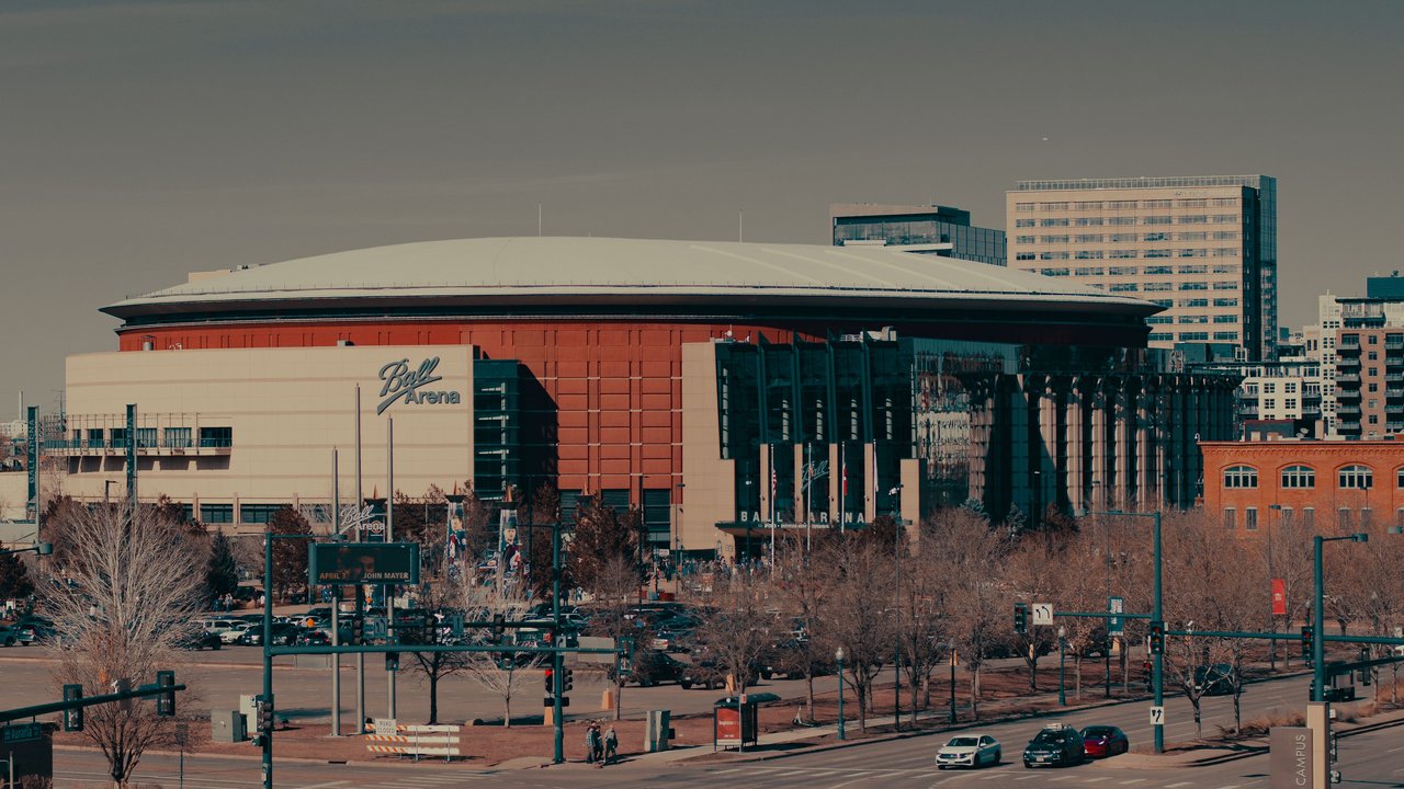 A daylight view of Ball Arena amidst Denver's urban landscape, highlighting its architectural design.
