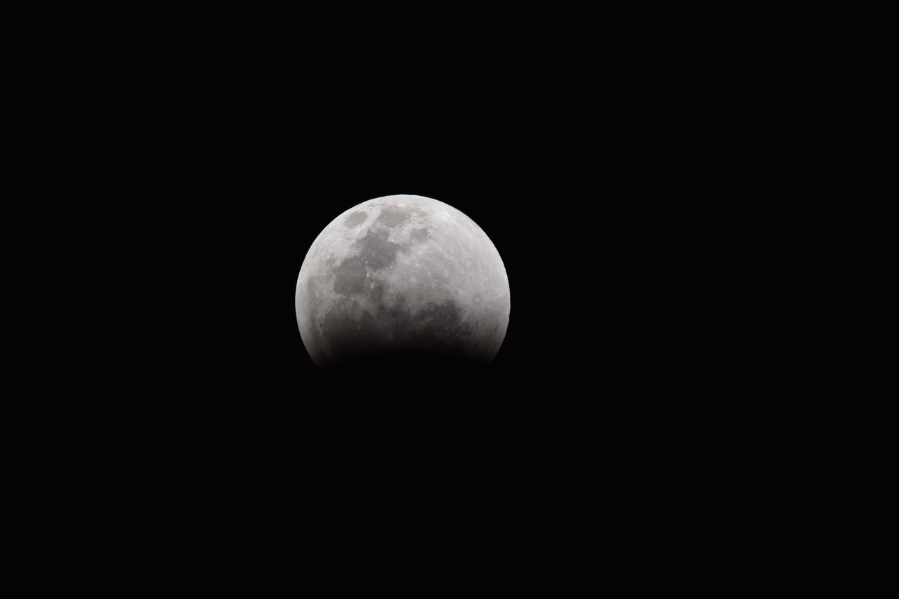 A stunning capture of the moon during a lunar eclipse, highlighting its shadow against the night sky.