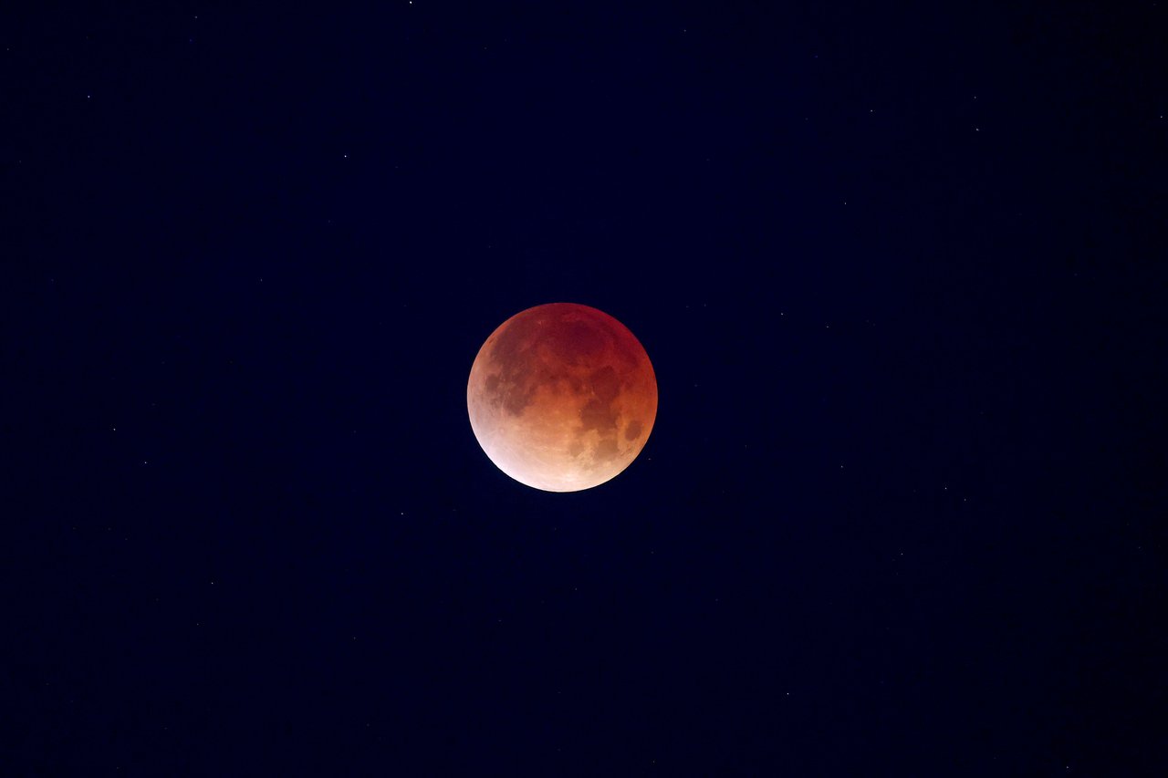 Captivating view of a blood moon amidst a starry night sky, showcasing a lunar eclipse.