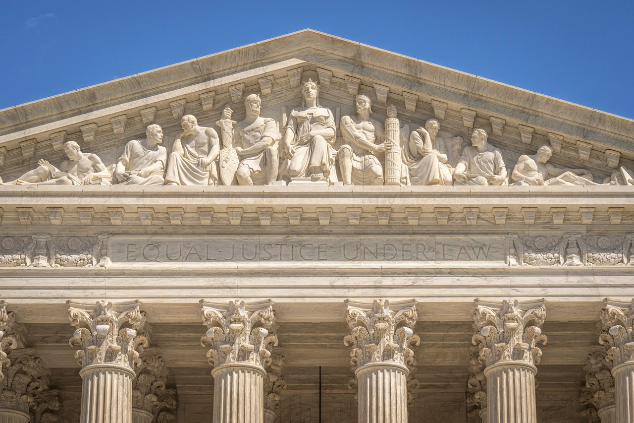 Detailed view of the Supreme Court Building's frontal frieze depicting historical figures and justices.
