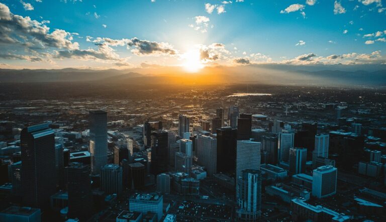 the sun is setting over a large city
